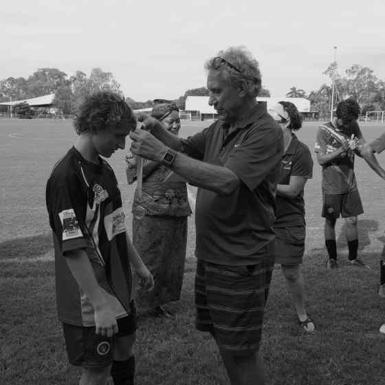 Charlie presenting the NO MORE Campaign Sportsmanship Medal to Palmerston player Cory.
