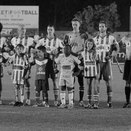 Darwin Olympic SC players link up before the match played in front of 2,300 local and interstate supporters.